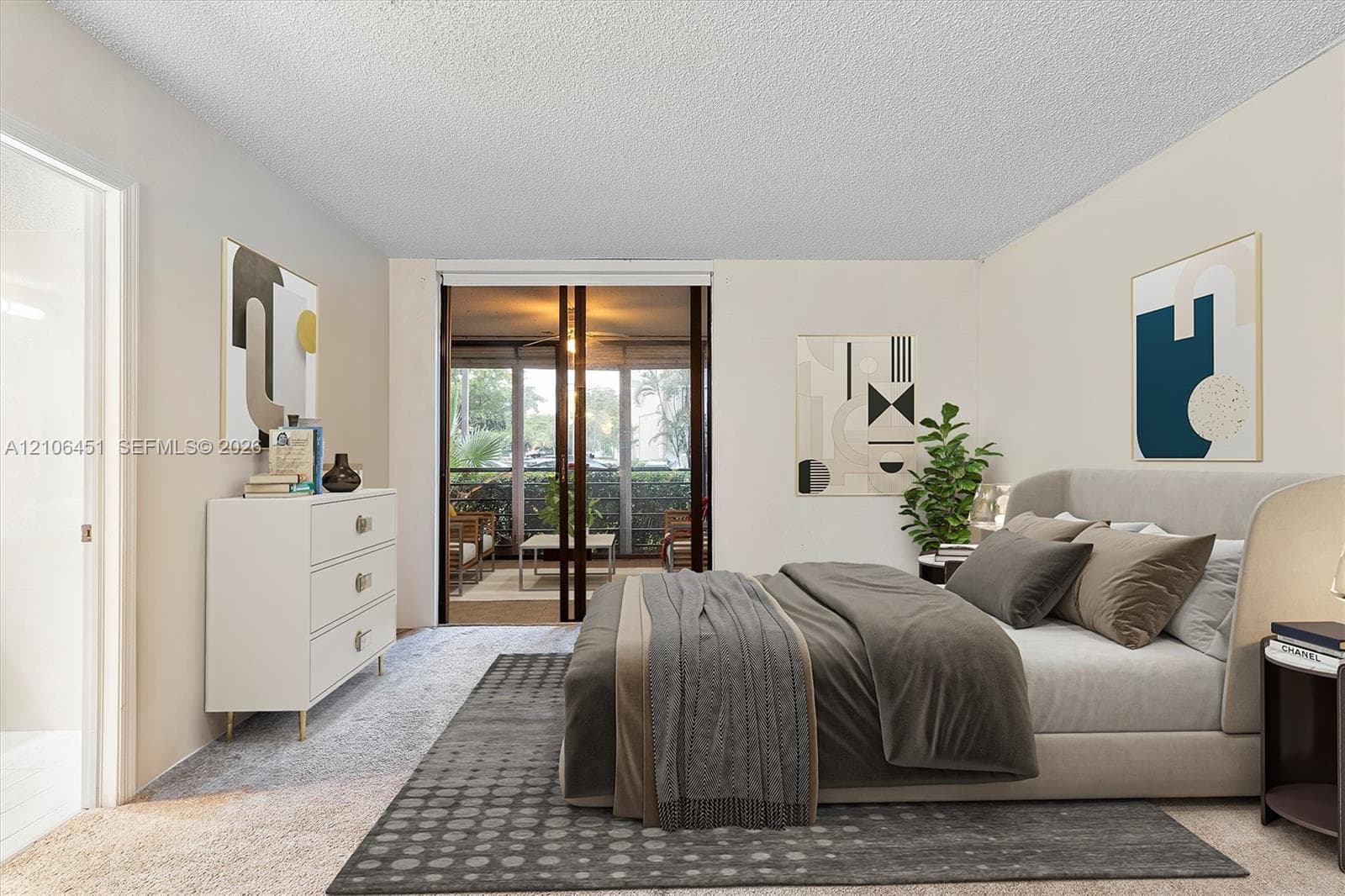 Neutral walls, textured ceiling, and sliding glass doors with exterior access