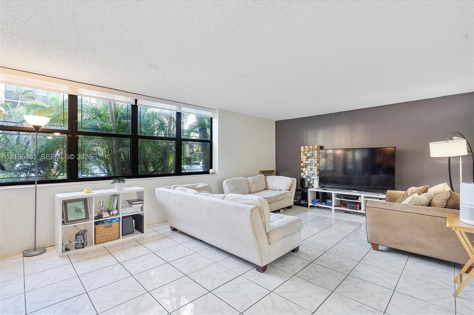 Large-format window assembly with black framing, polished tile flooring, and a decorative accent wall