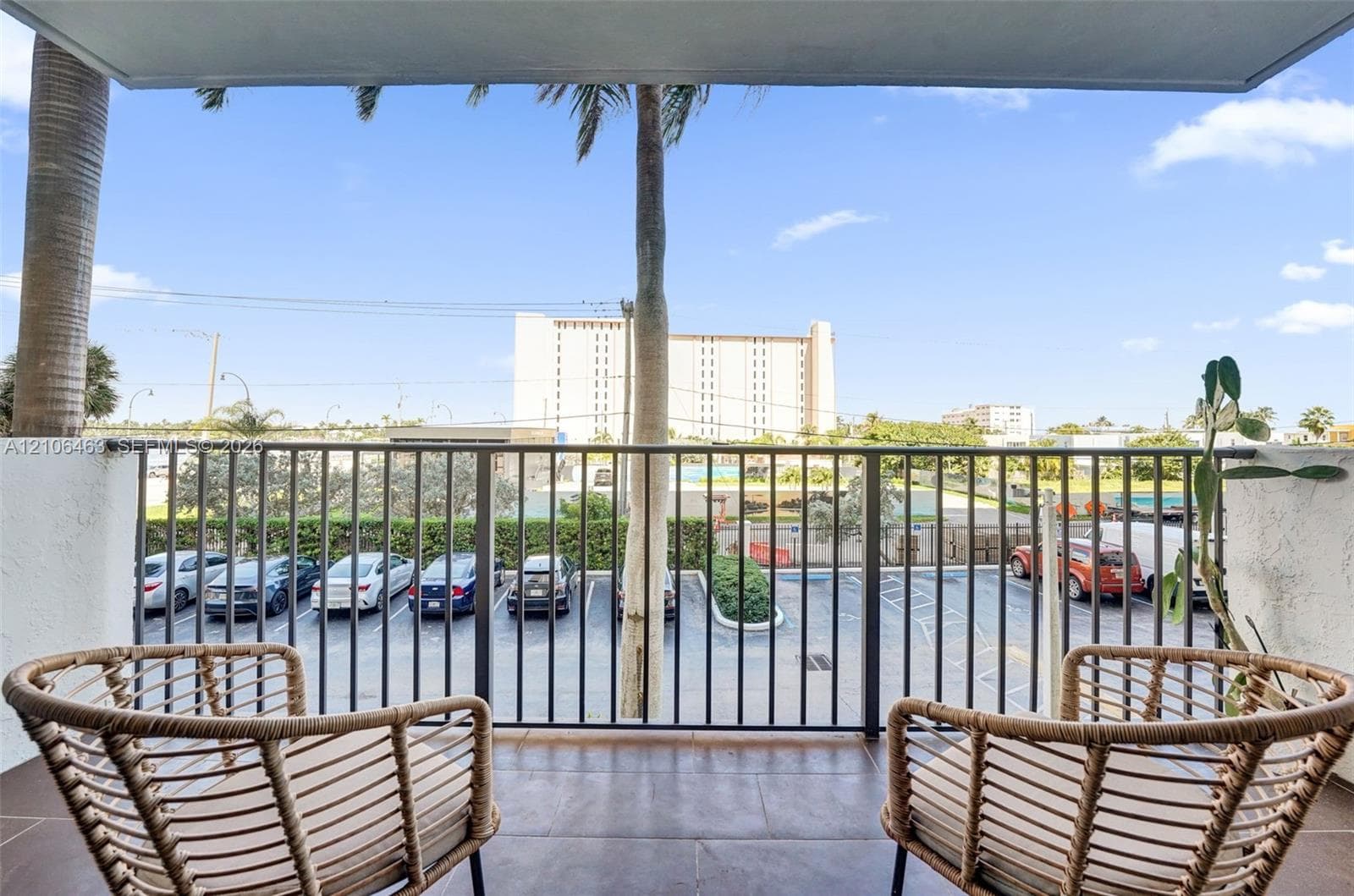 Covered balcony featuring tile flooring and a black metal railing