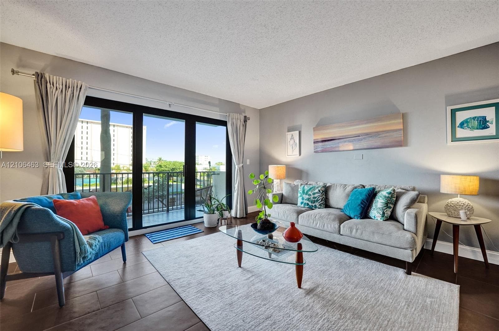 Living area featuring large-format tile flooring and expansive sliding glass doors opening to a private balcony