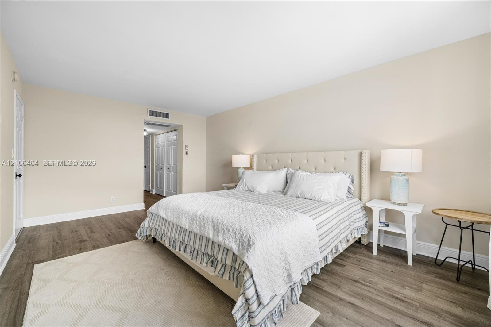 Neutral-toned interior space featuring wood-finish flooring and dual-panel closet doors