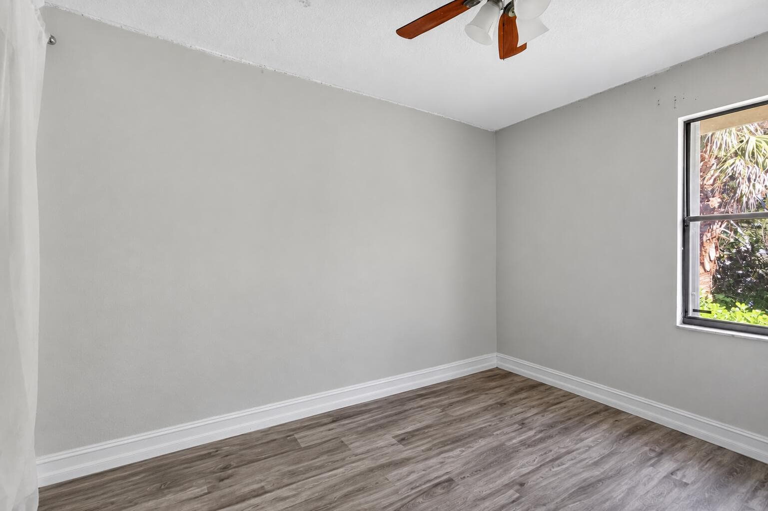 Empty gray bedroom with wood flooring