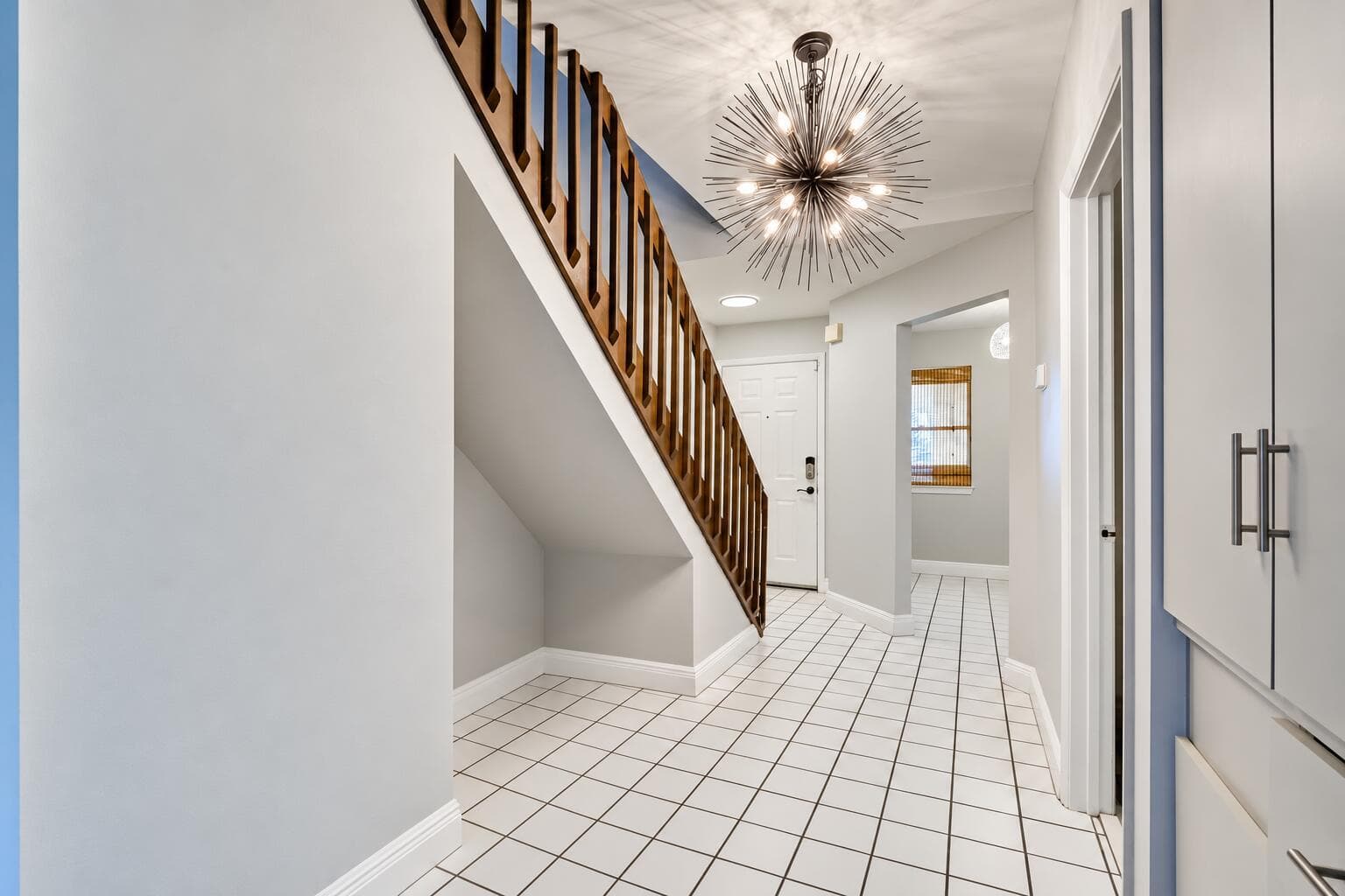 Unfurnished tiled entryway with staircas