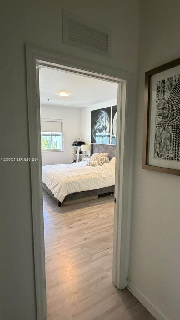 Wood-finish flooring and a single-pane window with roller shade