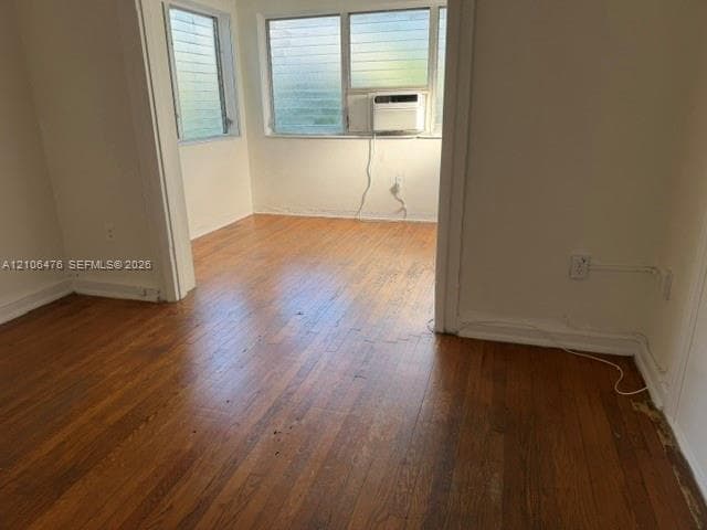 Wood-finish flooring throughout, louvered glass windows, and a built-in wall-mounted air conditioning unit