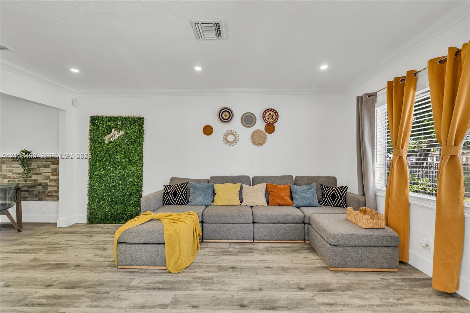 Living area featuring wood-finish flooring, recessed lighting, and crown molding