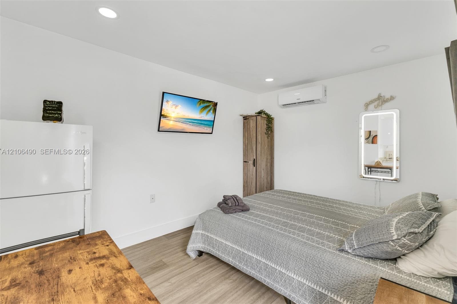 Wood-finish flooring, recessed lighting, and wall-mounted climate control unit