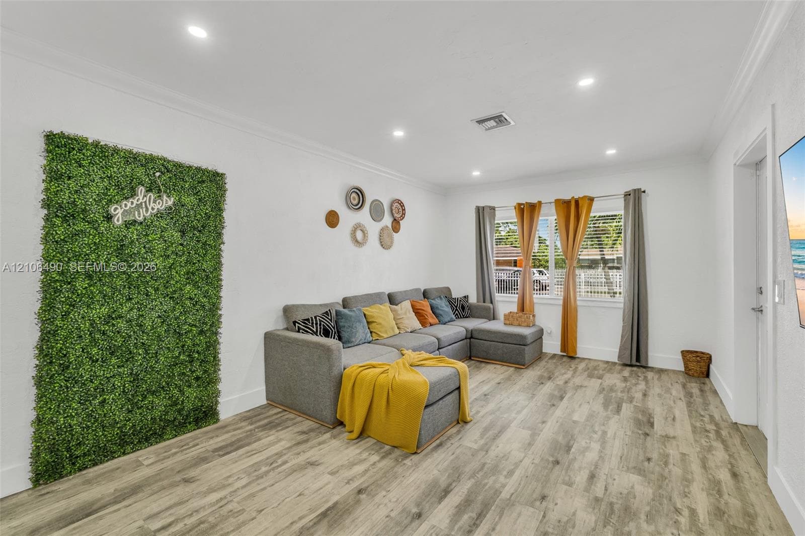 Interior space featuring wood-finish flooring, recessed lighting, and a textured green accent wall
