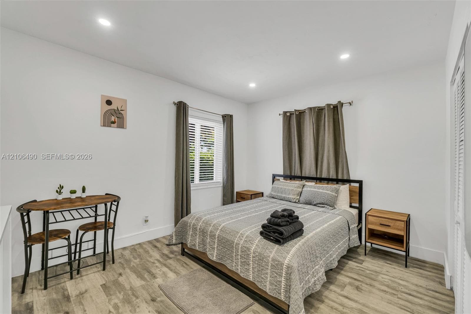 Neutral interior space featuring wood-finish flooring, recessed lighting, and louvered closet doors
