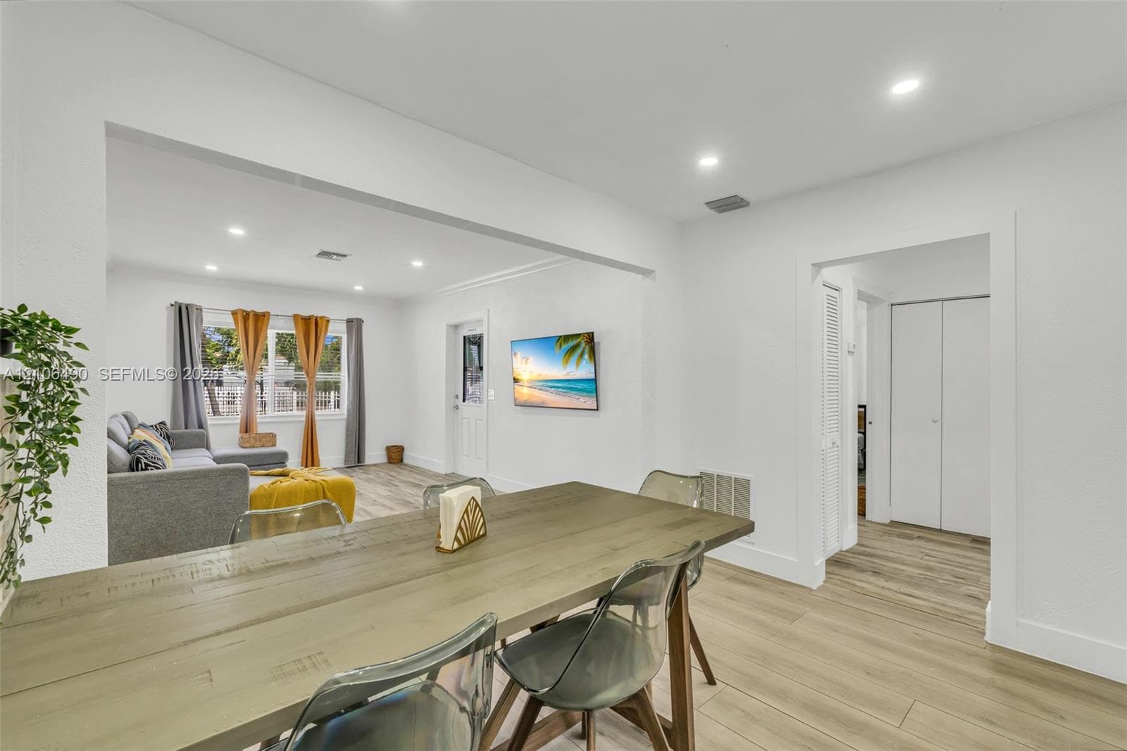 Open-concept interior featuring light-toned wood-finish flooring, recessed ceiling lighting, and crisp white wall finishes