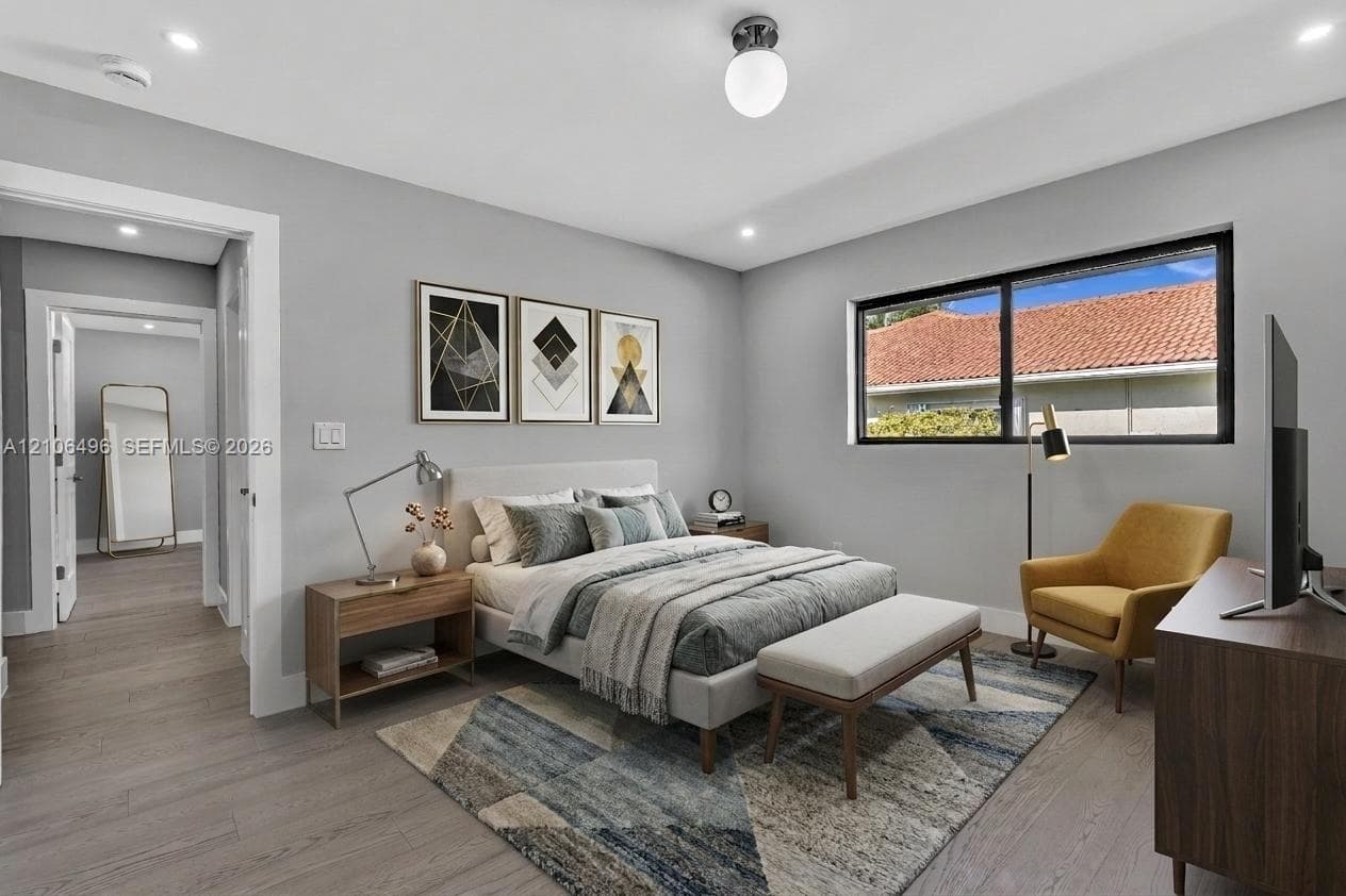 Neutral-toned interior featuring wood-finish flooring, recessed lighting, a modern spherical ceiling fixture, and a large horizontal window with a black frame