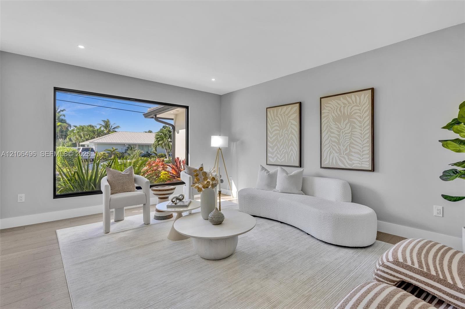 Living space featuring large-format black-frame windows, neutral wall tones, and recessed lighting