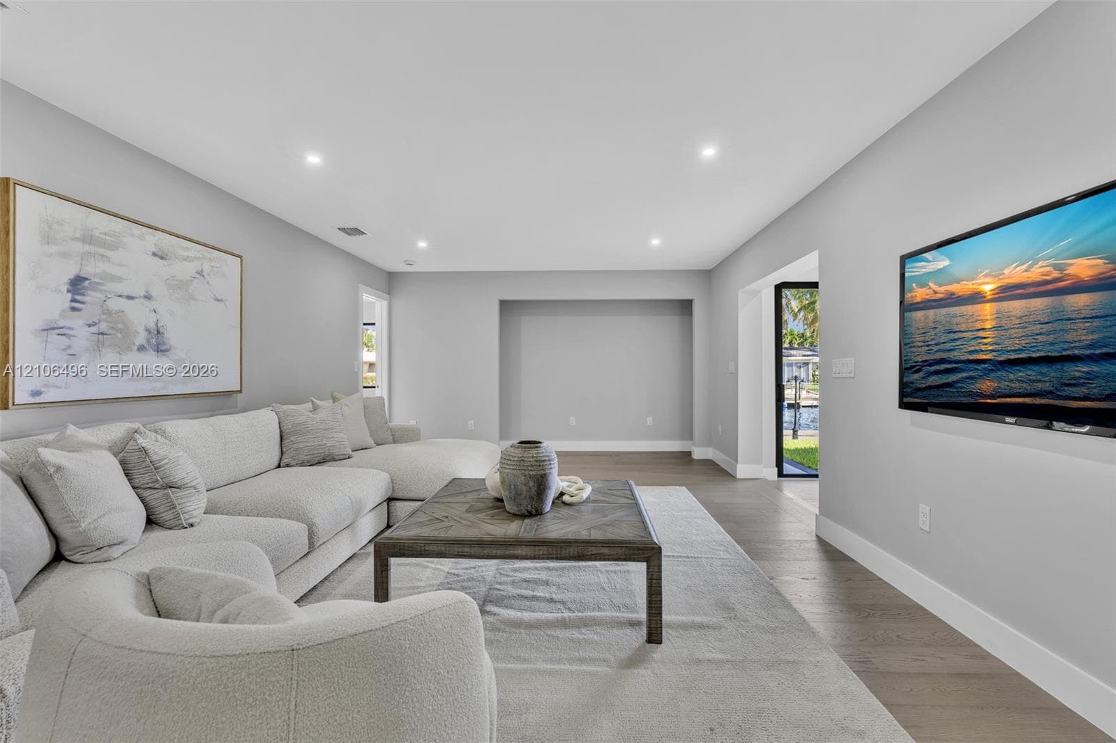Living area featuring wood-finish flooring, recessed lighting, and a recessed wall niche