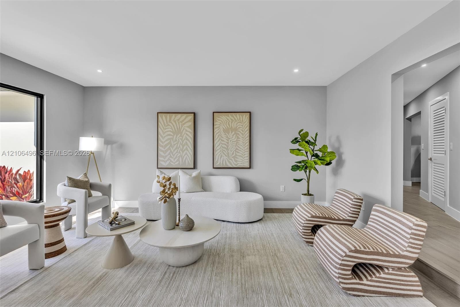 Neutral interior space featuring wood-finish flooring, recessed lighting, and a large floor-to-ceiling glass panel door