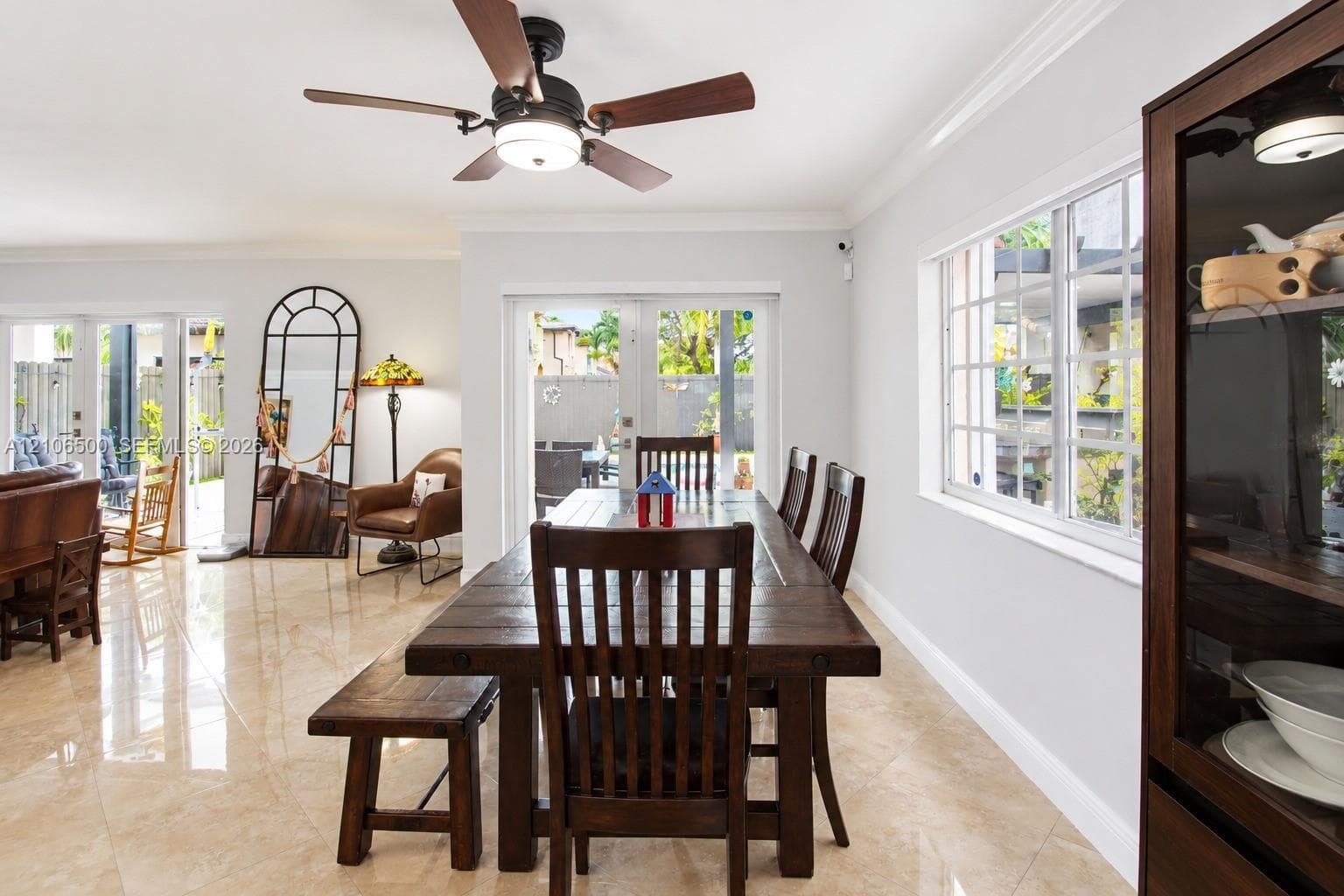 Large-format polished tile flooring, multi-pane windows, and a ceiling-mounted light fixture with a fan