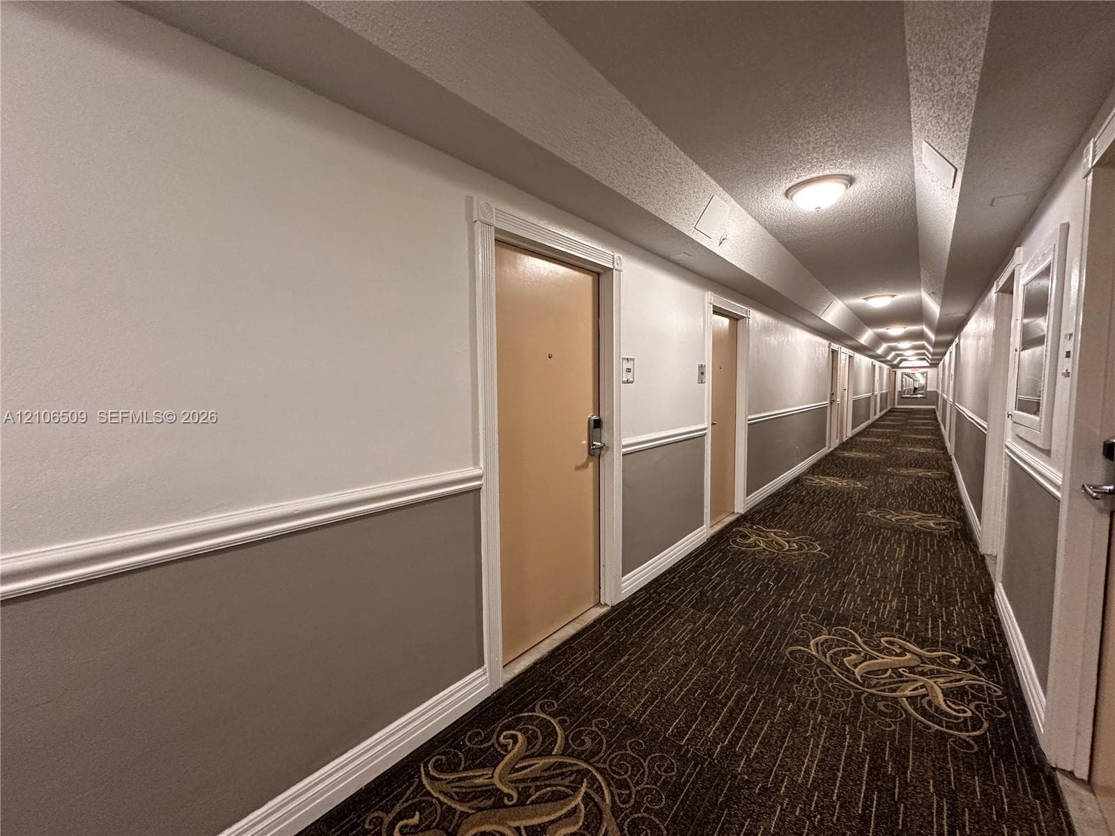 Hallway featuring patterned carpeting, two-toned wall paint, decorative chair rail molding, and recessed ceiling lighting