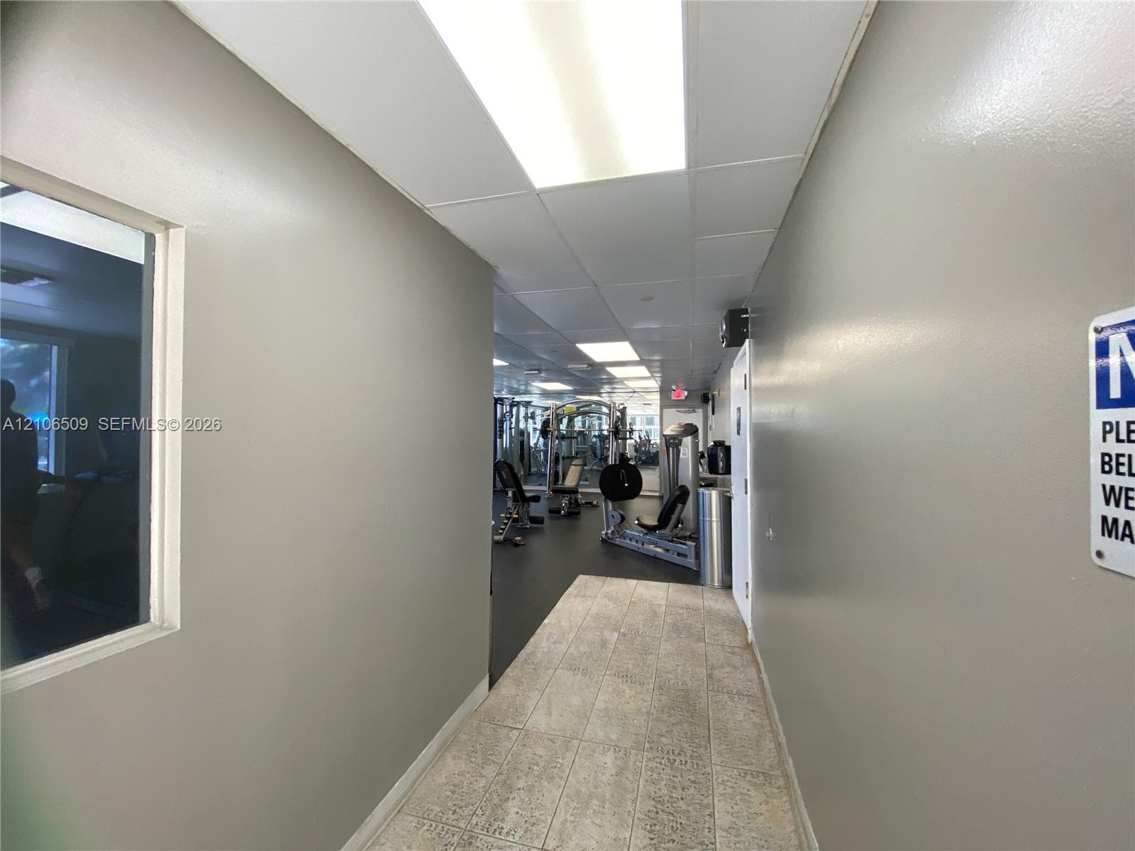 Fitness area featuring inset ceiling lighting, tile flooring, and gym equipment