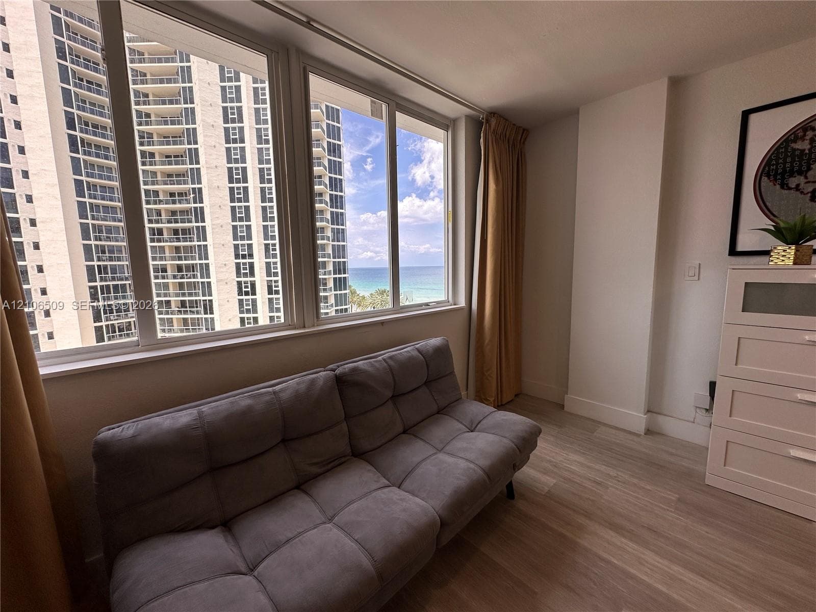 Large-format windows featuring ocean and coastal scenery with wood-finish flooring