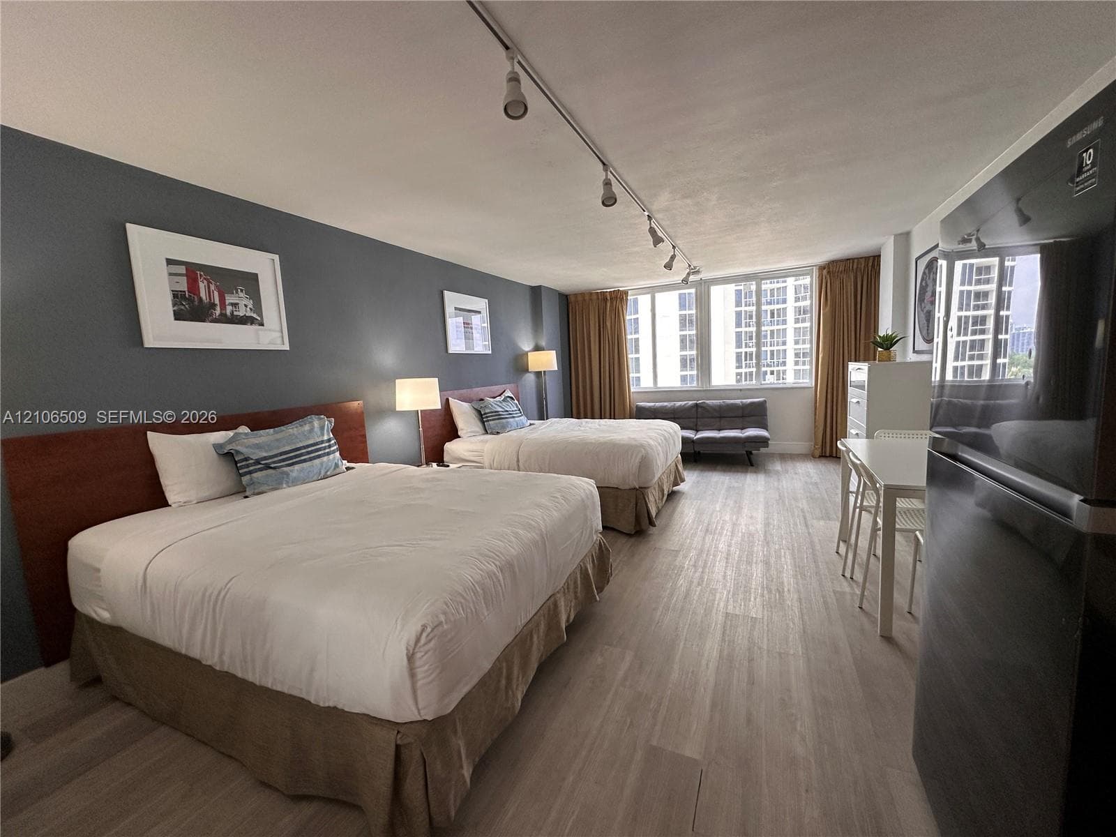 Room featuring wood-finish flooring, track lighting, and expansive windows