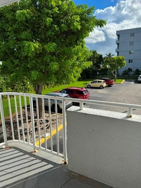 Balcony featuring white metal railings and concrete flooring