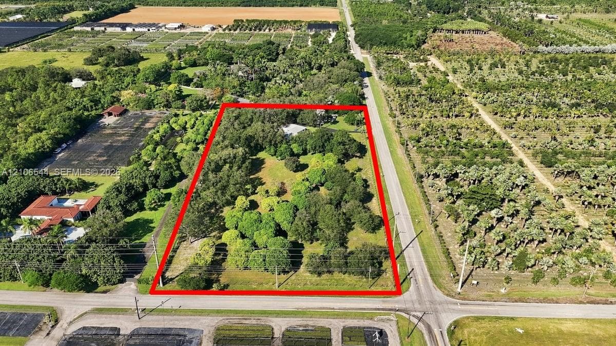 Expansive parcel featuring mature oak trees, paved driveway, and established landscape