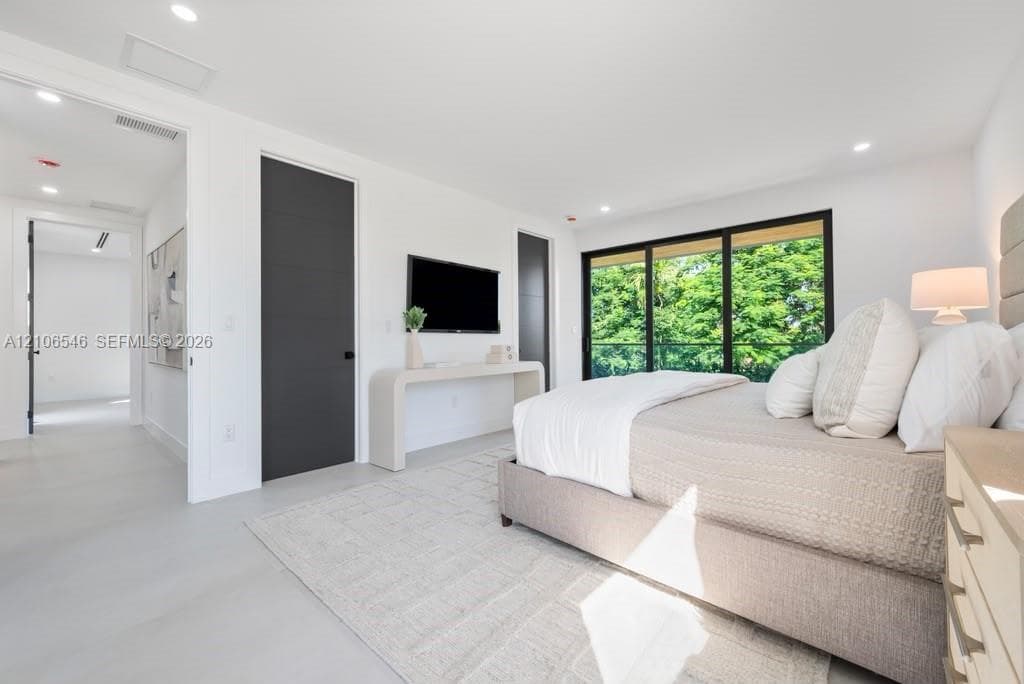 Recessed lighting, smooth-finish flooring, floor-to-ceiling sliding glass doors, and dark-finished doors with horizontal accents