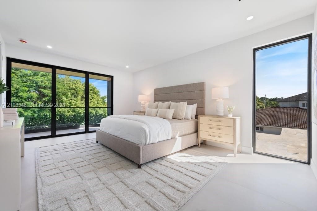 Large sliding glass doors, floor-to-ceiling windows with black frames, smooth-finish flooring, and recessed ceiling lighting