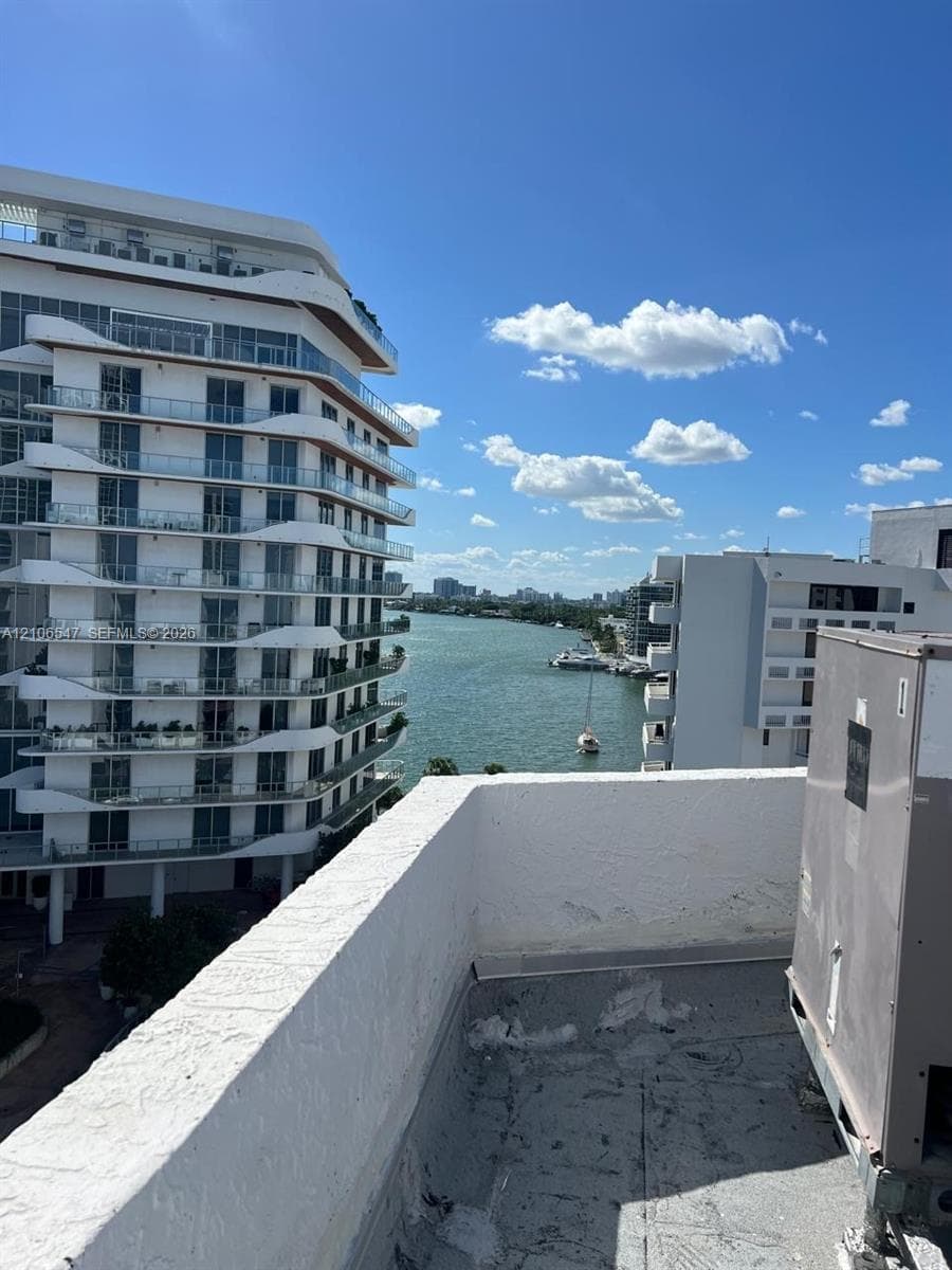 Rooftop terrace with stucco parapet wall and prominent water scenery