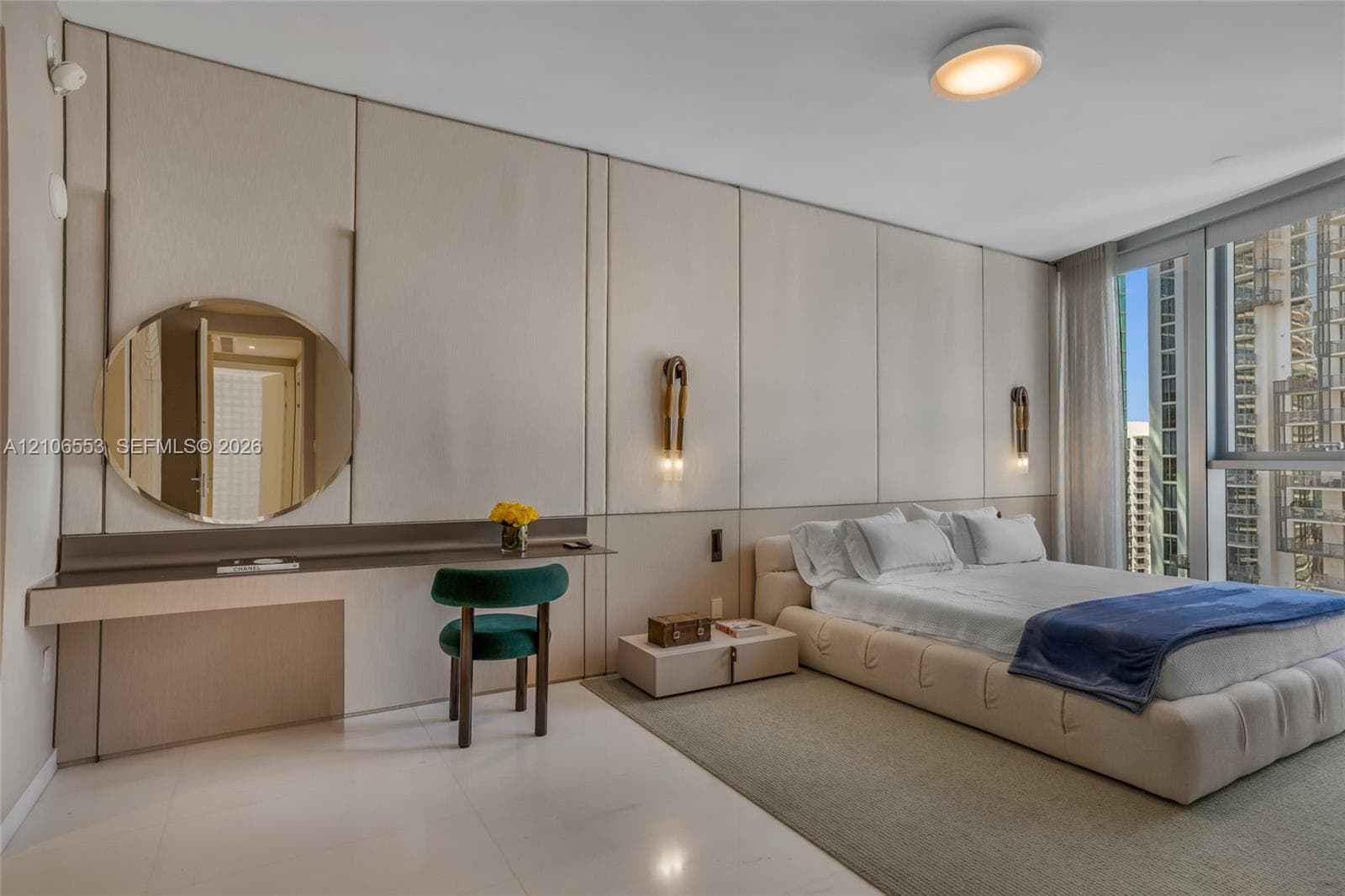 Custom floor-to-ceiling wall paneling, built-in floating desk, integrated circular mirror, wall-mounted light fixtures, and floor-to-ceiling windows