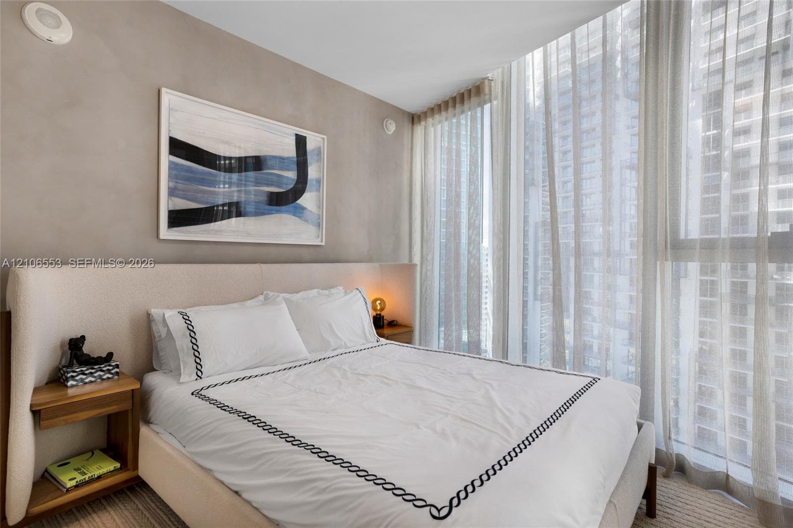 Full-height floor-to-ceiling windows with integrated drapery track, neutral textured wall finish, and wall-to-wall carpeting