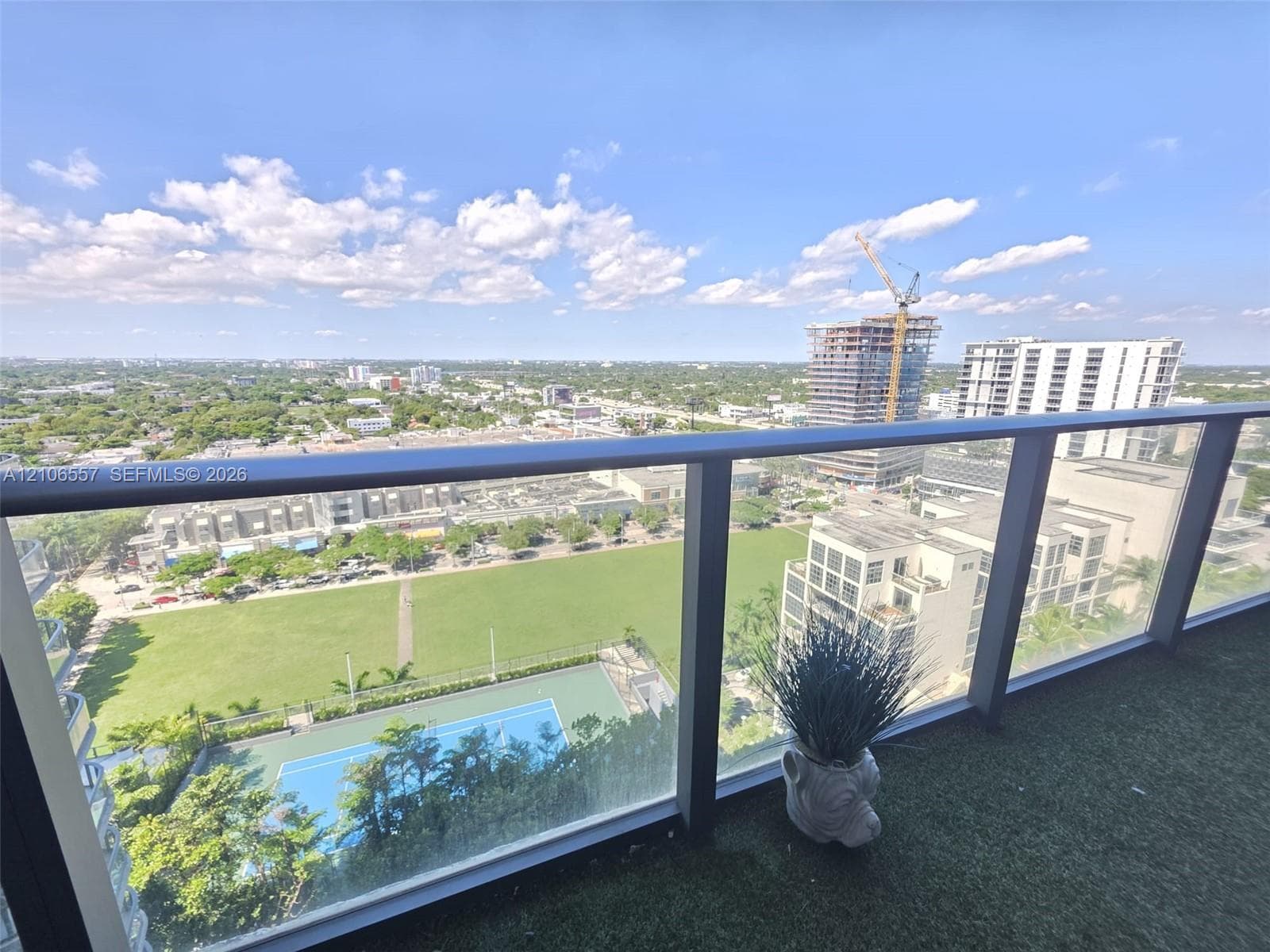 Covered balcony with high-rise metal railings and synthetic turf flooring
