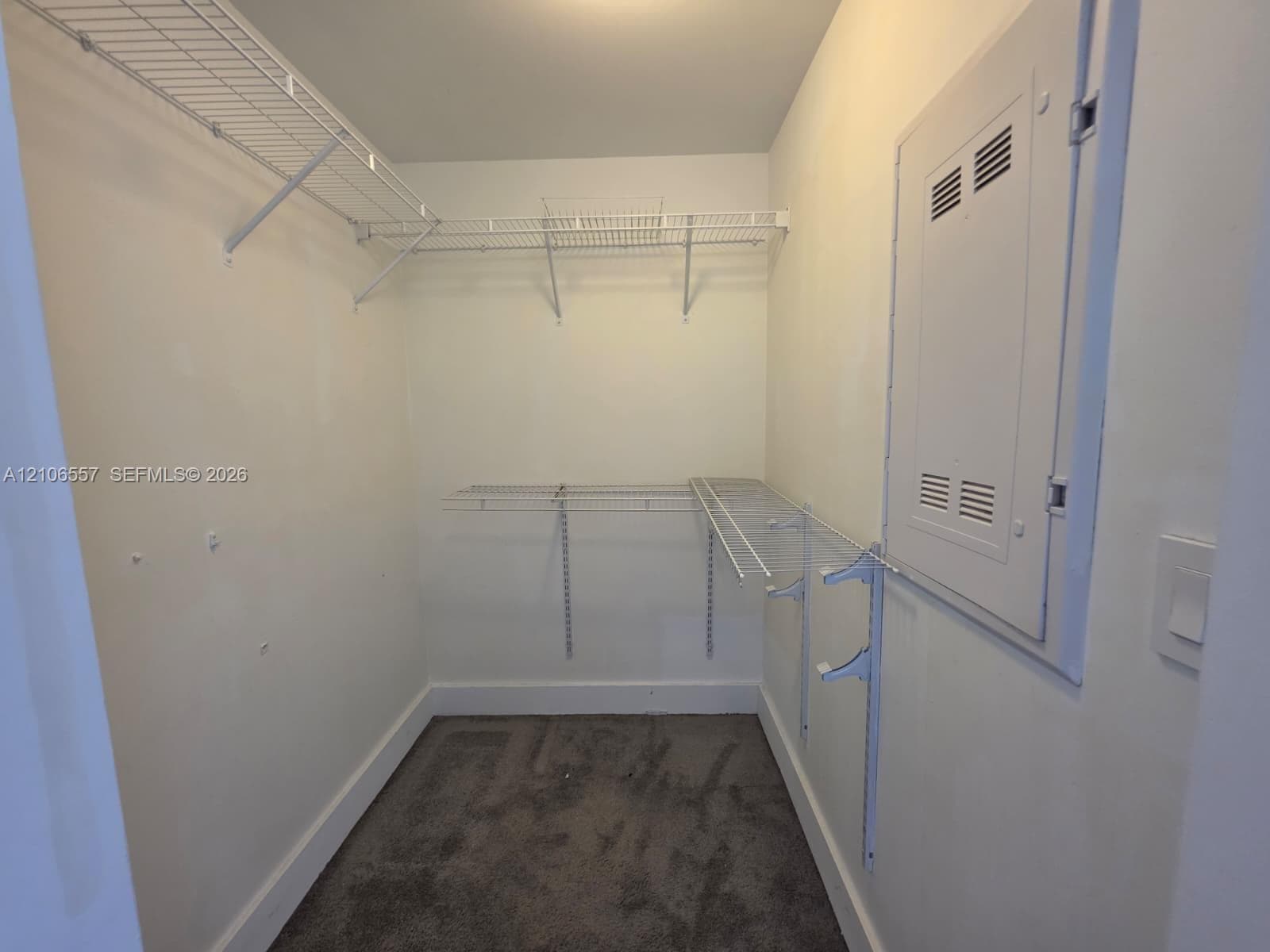Storage space featuring multi-level wire shelving and carpeted flooring