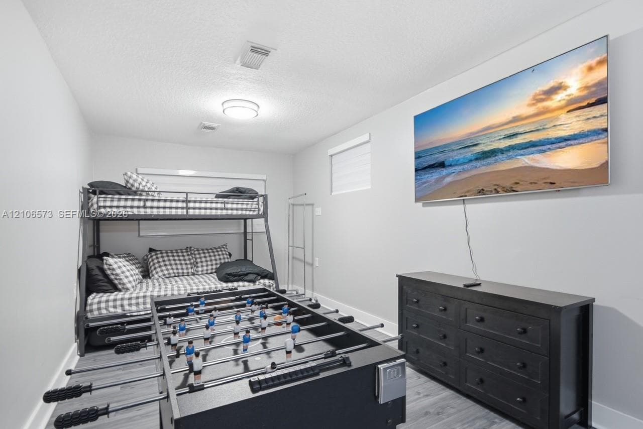Neutral-toned interior space featuring wood-finish flooring, white walls, and dual recessed lighting fixtures