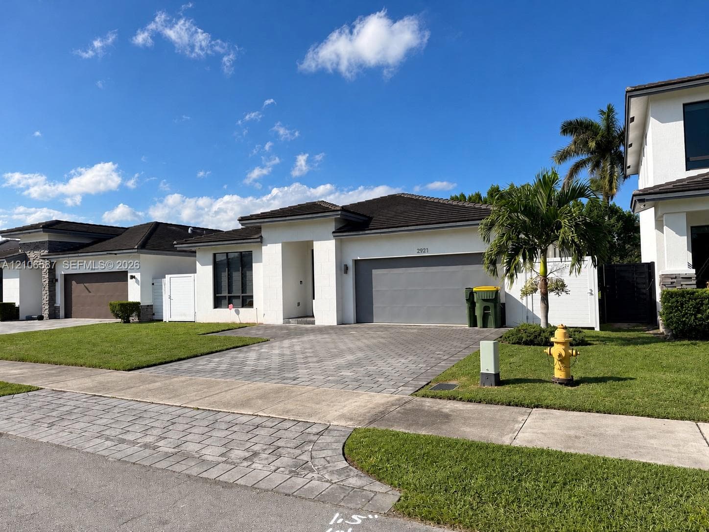Single-story stucco exterior with a hip roof, paved driveway, and attached two-car garage