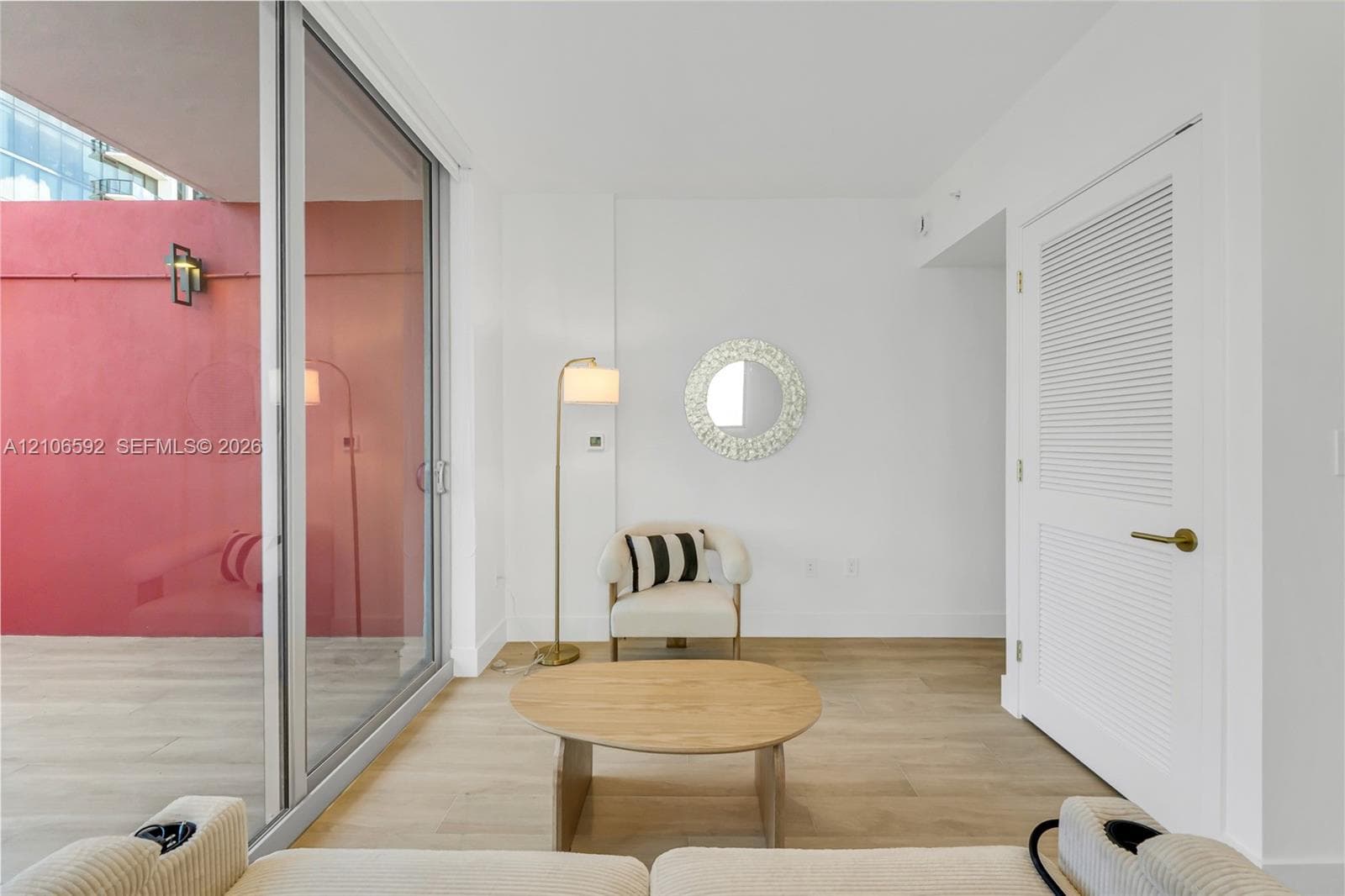 Floor-to-ceiling sliding glass door, wood-finish flooring, and white louvered door