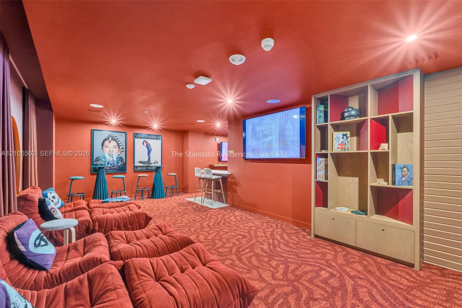 Built-in multi-level wood cabinetry, patterned carpeting, recessed ceiling lighting, and wall-mounted display screen