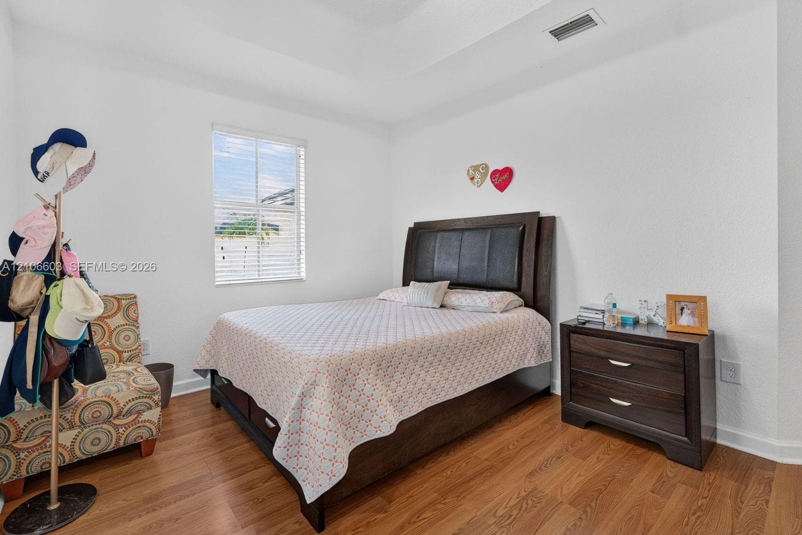 Tray ceiling, wood-finish flooring, and window with horizontal blinds