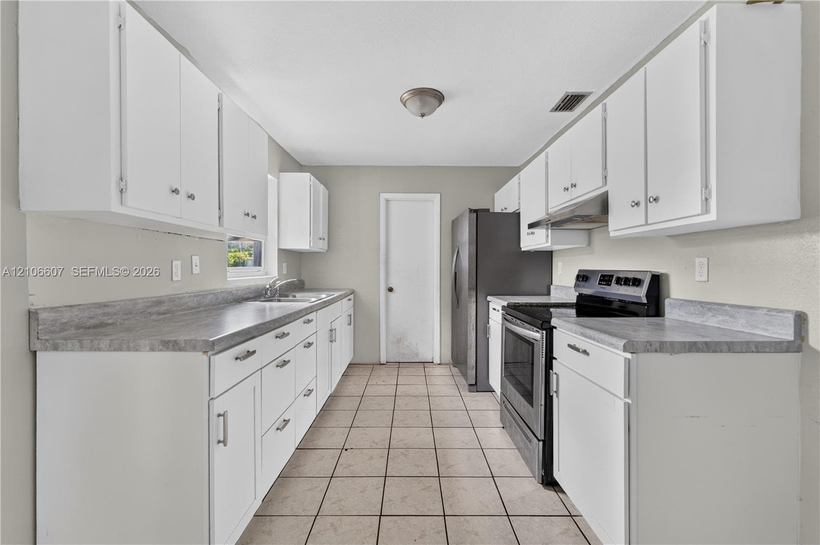 Kitchen featuring white cabinetry, stone-finish countertops, stainless steel appliances, and ceramic tile flooring