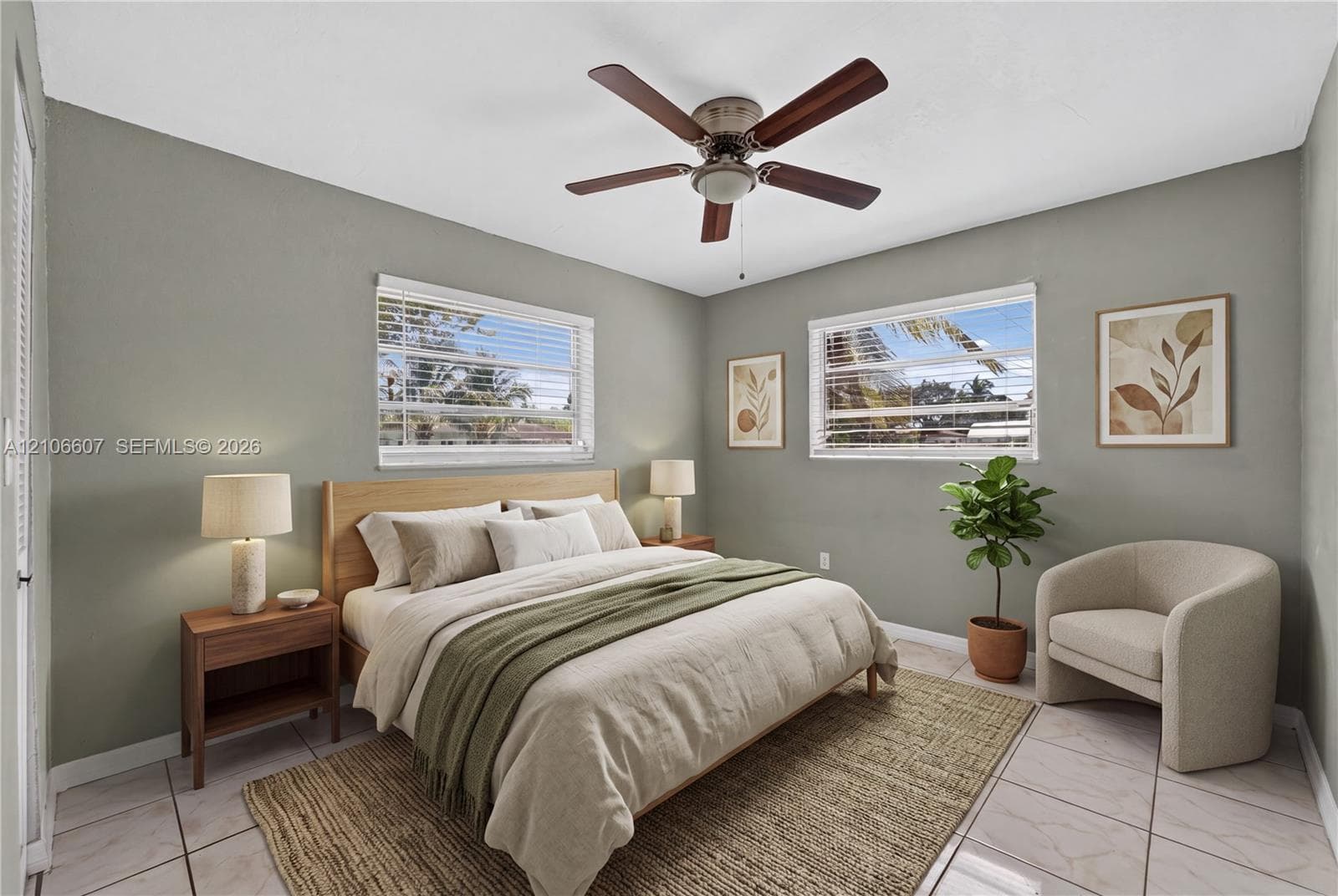 Bedroom featuring large-format ceramic tile flooring, neutral wall tones, two horizontal windows with slatted blinds, and a central ceiling fan with integrated lighting