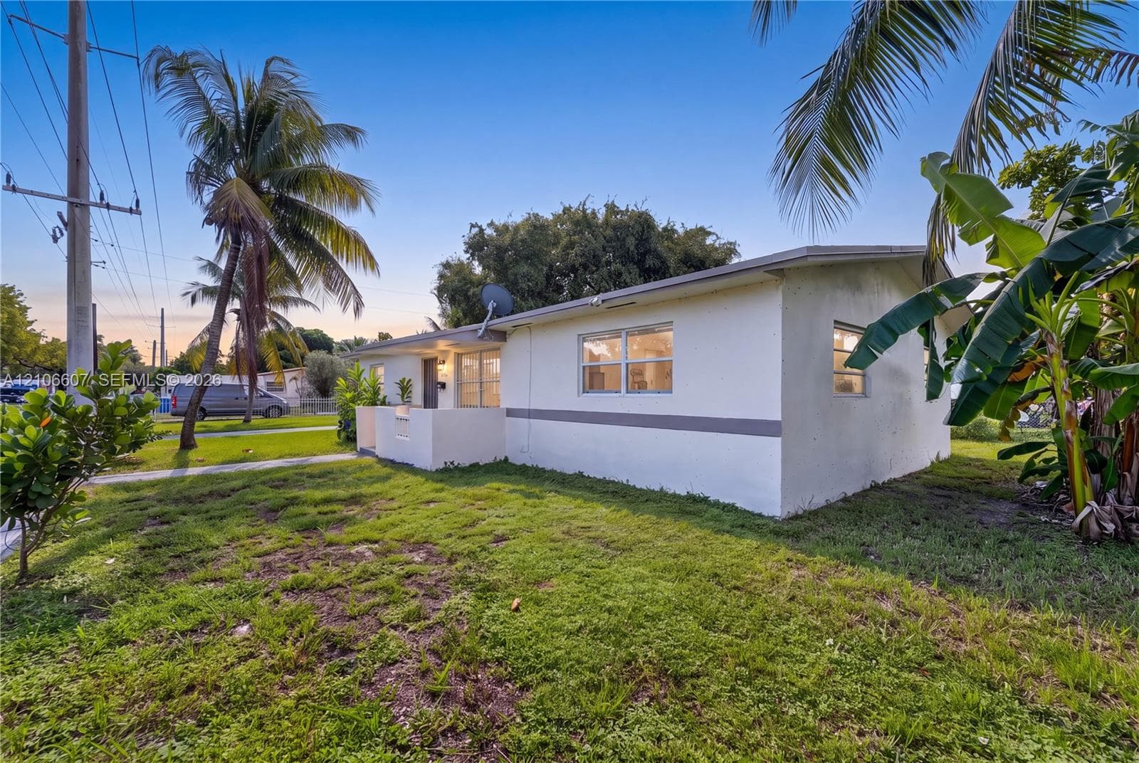 Single-story exterior featuring light-toned masonry walls, horizontal accent banding, and a covered entryway with a low-profile concrete wall