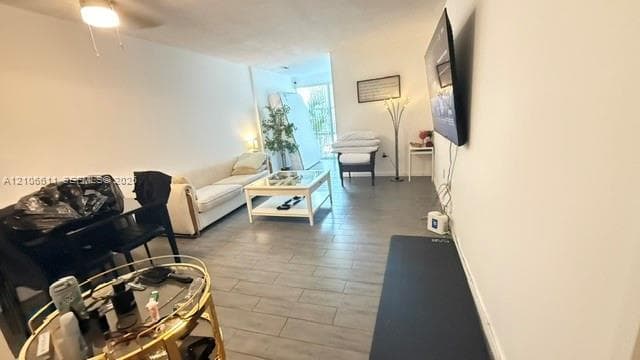 Interior space featuring neutral wall tones, grey tile flooring, a ceiling-mounted light fixture, and a large sliding glass door