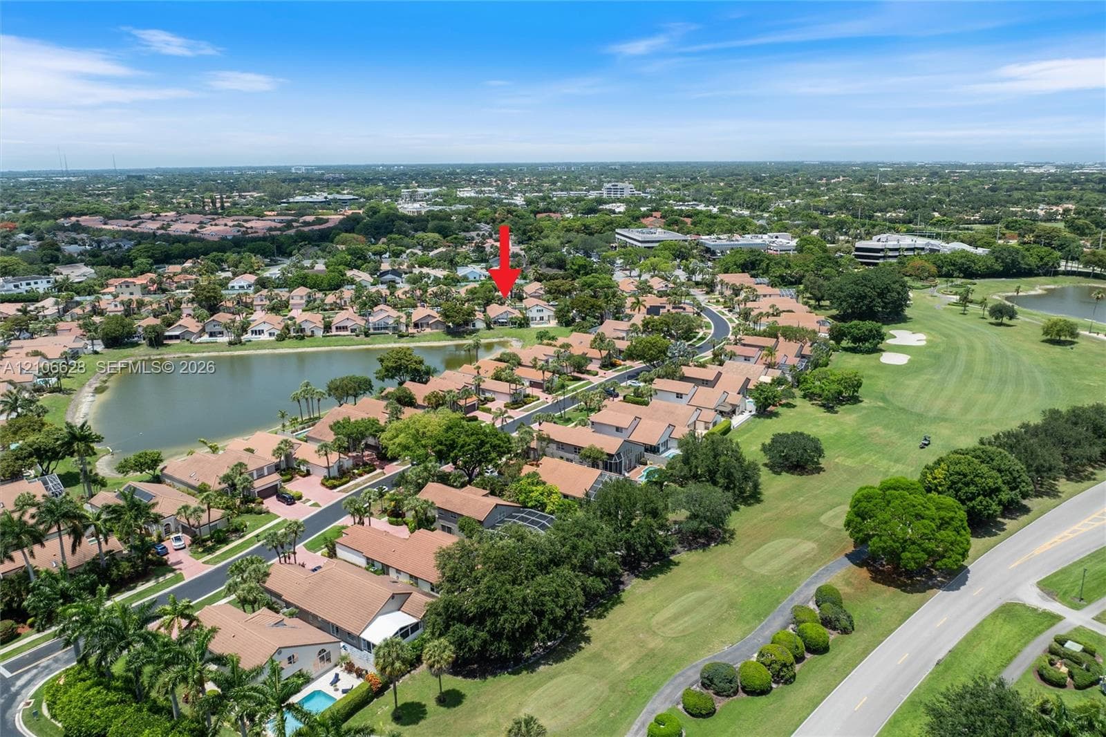 Aerial perspective of residential property featuring tile roof construction, proximity to a lake, mature landscaping, and integration into a golf course community