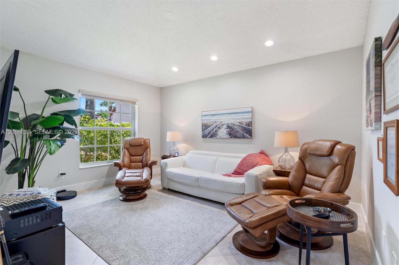 Neutral wall-toned room featuring recessed lighting, tile flooring, and a large multi-pane window