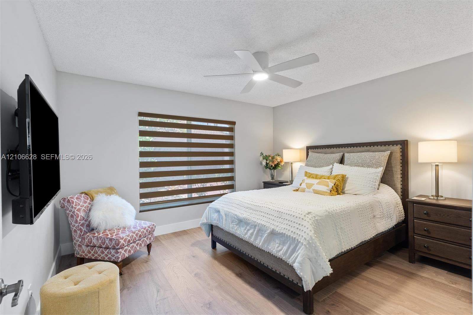 Wood-finish flooring, ceiling fan with integrated lighting, and horizontal dual-layer privacy blinds