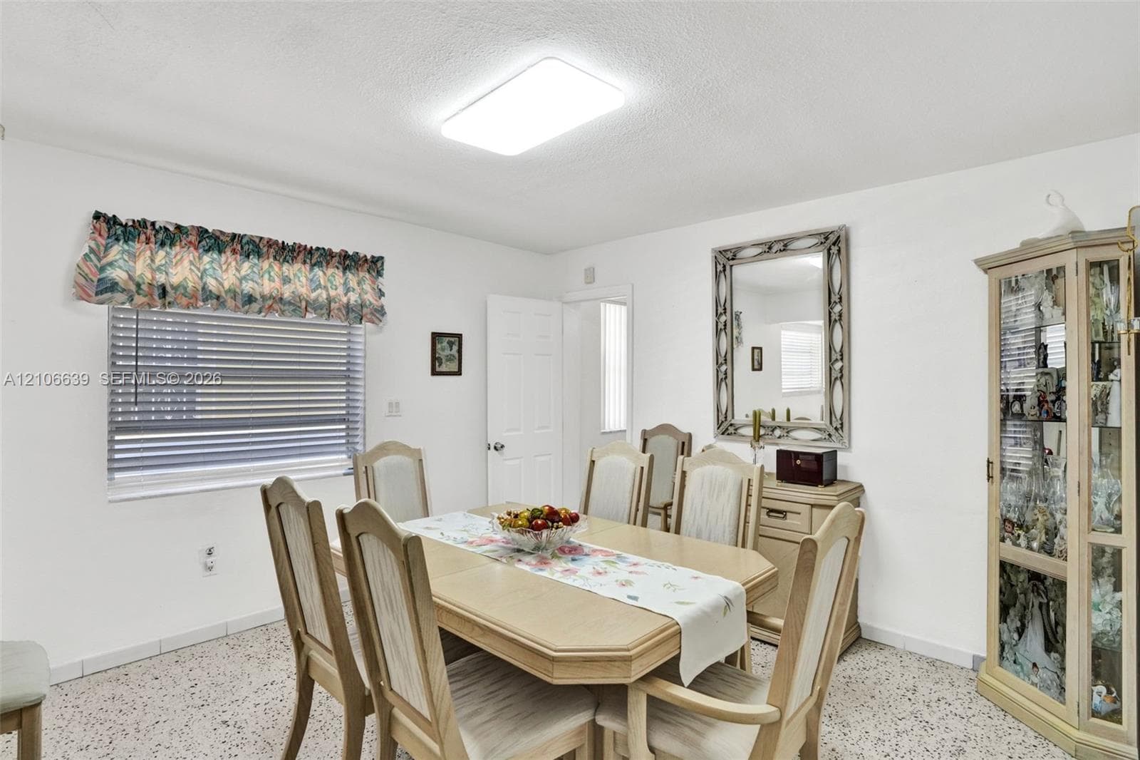 Interior space featuring terrazzo flooring, horizontal window blinds, and a flush-mount rectangular light fixture