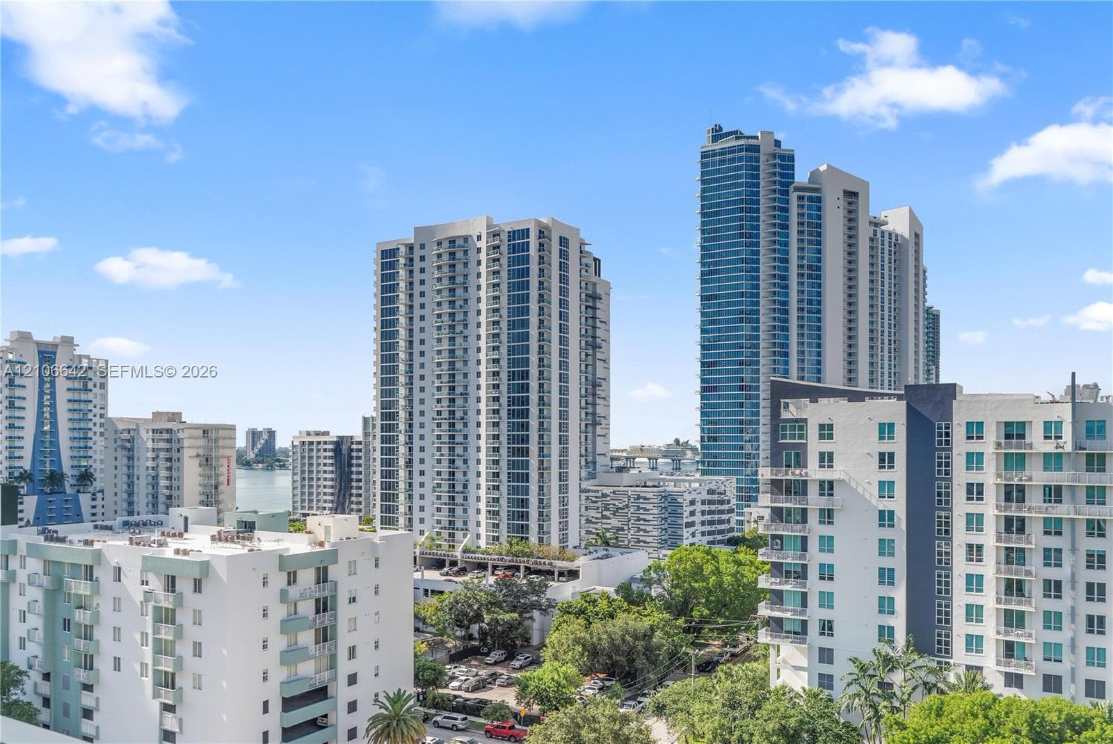 High-rise urban landscape featuring multiple glass-facade residential towers, concrete building exteriors, and mature canopy trees
