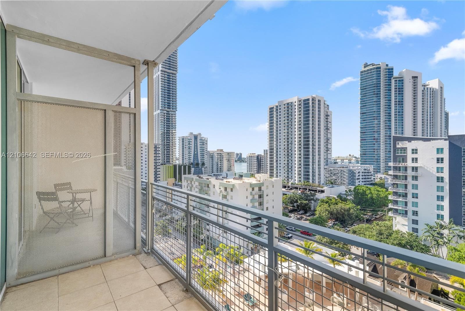 Private balcony featuring tiled flooring, a powder-coated metal railing, and a privacy screen