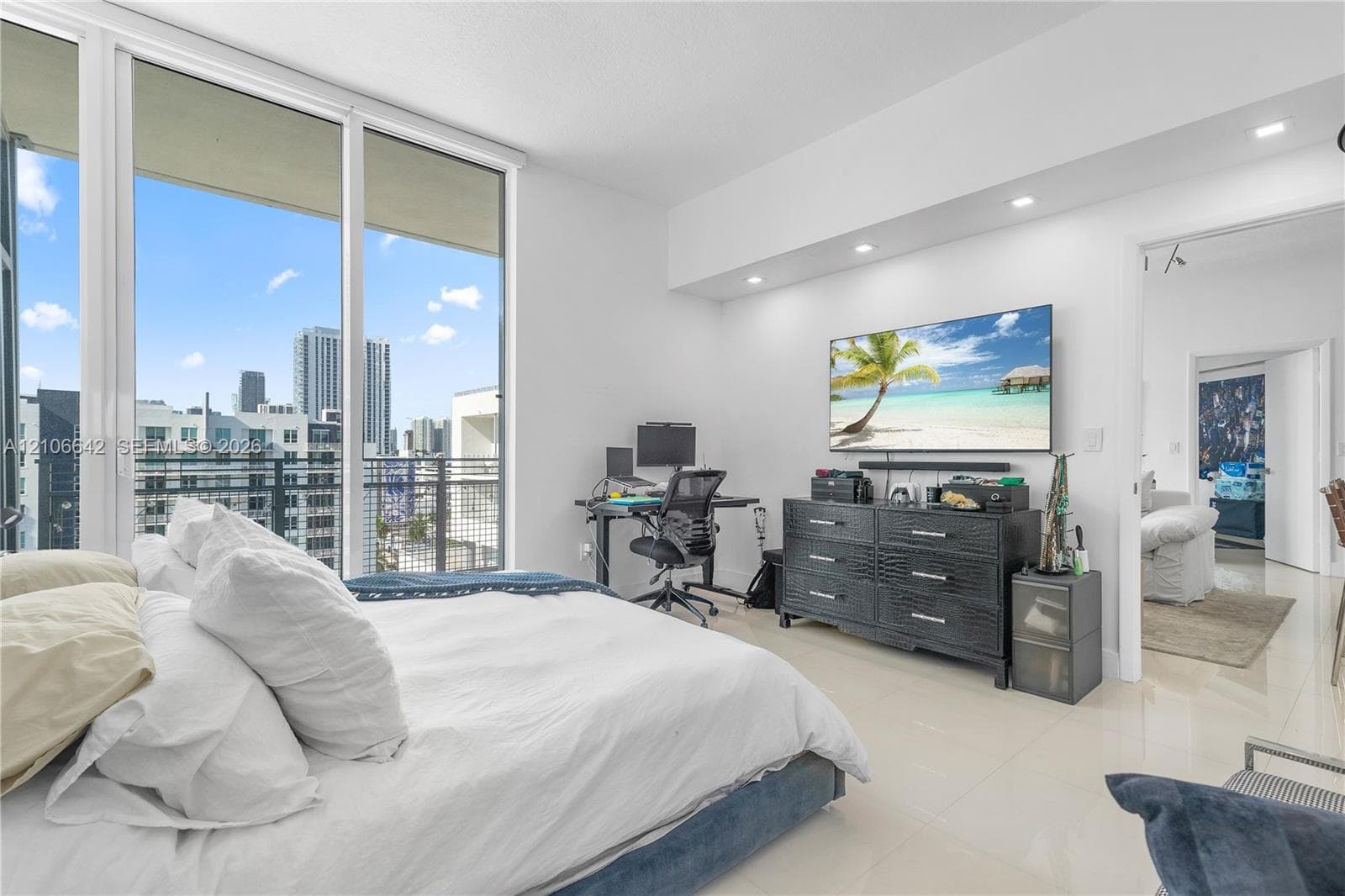 Floor-to-ceiling windows, polished tile flooring, recessed ceiling lighting, and a metal-railing balcony