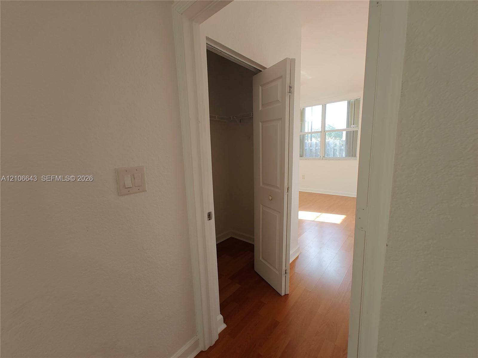 Wood-finish flooring, interior closet with wire shelving, and multi-pane window