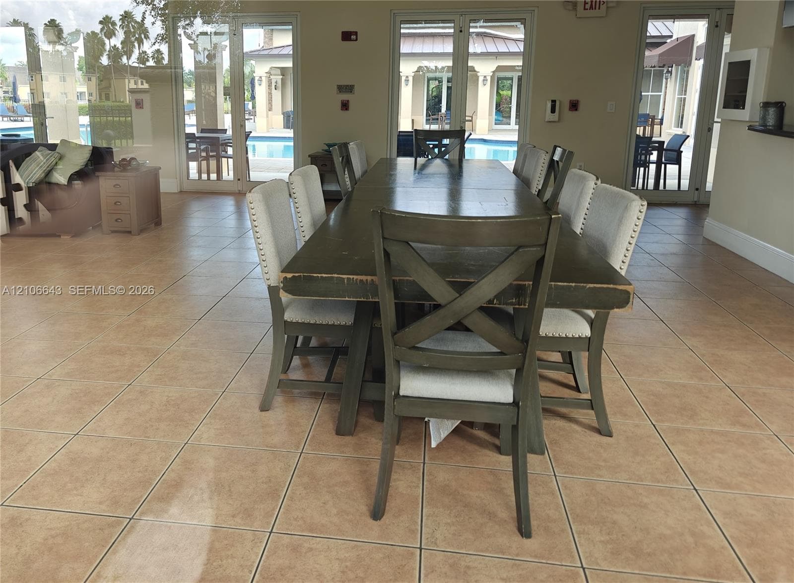 Large format tile flooring featuring neutral tones and multiple glass doors providing exterior exposure